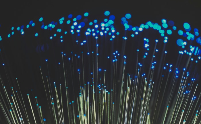 Glowing fiber optic cables with blue lights against a dark background