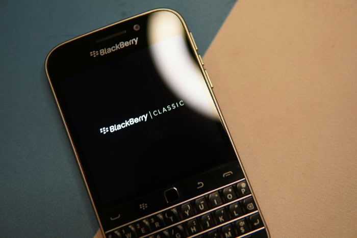 Gold BlackBerry Classic phone showing startup screen display