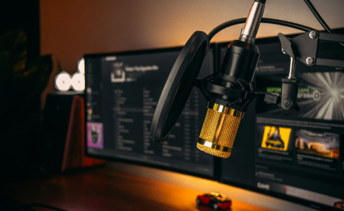 Gold condenser microphone in front of monitors
