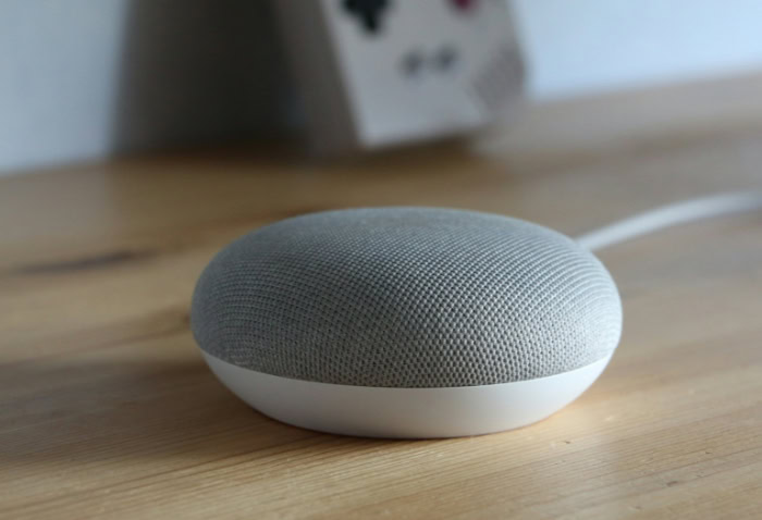 Google Nest Mini smart speaker on wooden table