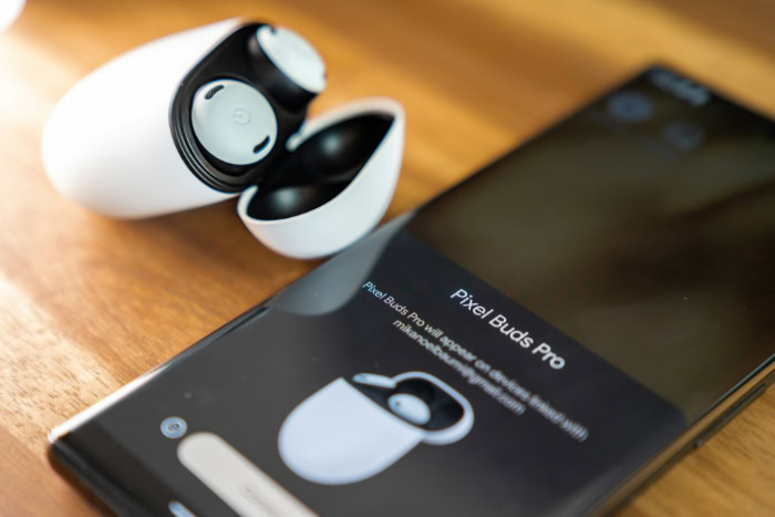 Google Pixel Buds Pro in case next to smartphone