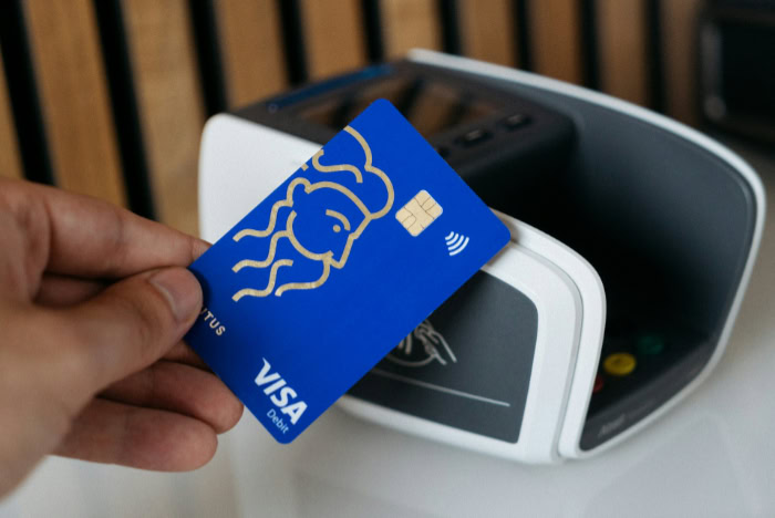 Hand holding Visa card for contactless payment