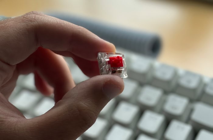 Hand holding a red linear mechanical keyboard switch