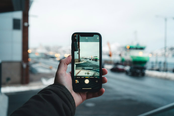 Hand holding an iPhone taking a harbor photo