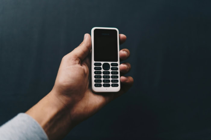 Hand holding black burner phone