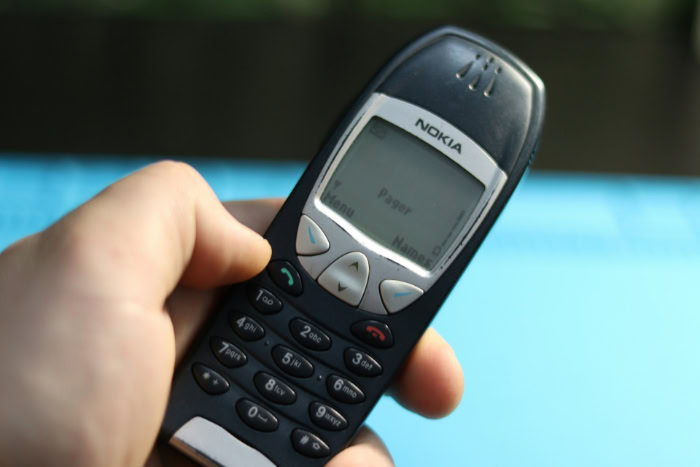 Hand holding classic Nokia burner phone