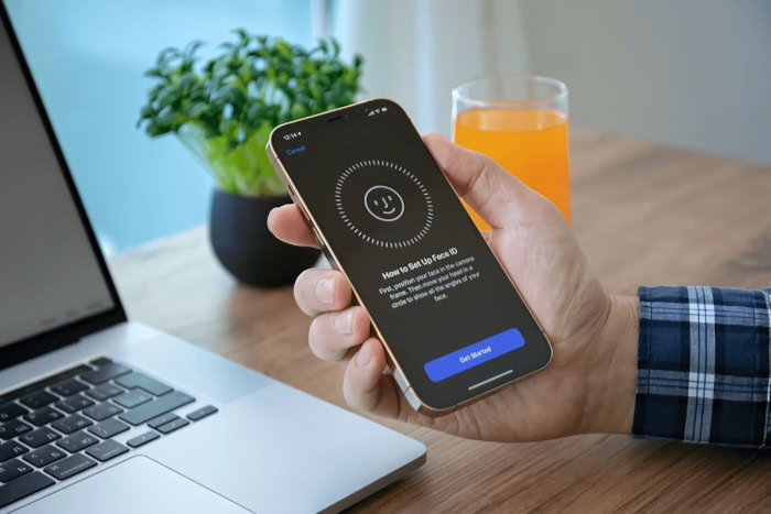 Hand holding iPhone showing Face ID setup instructions