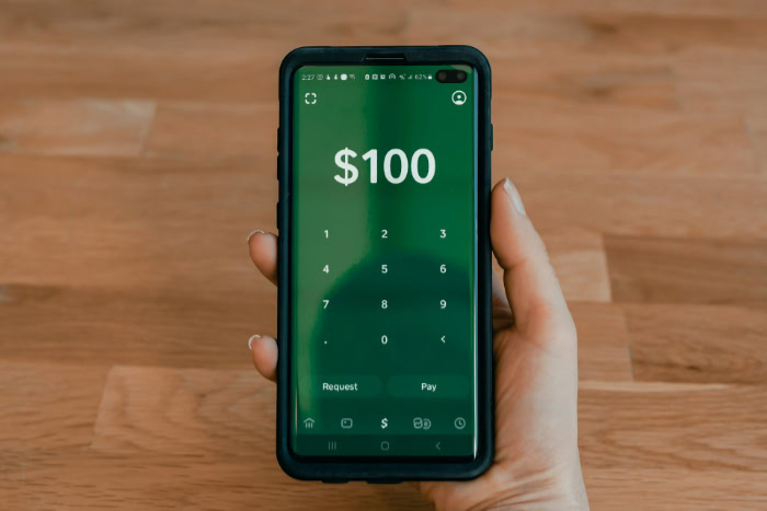 Hand holding phone showing Cash App payment screen