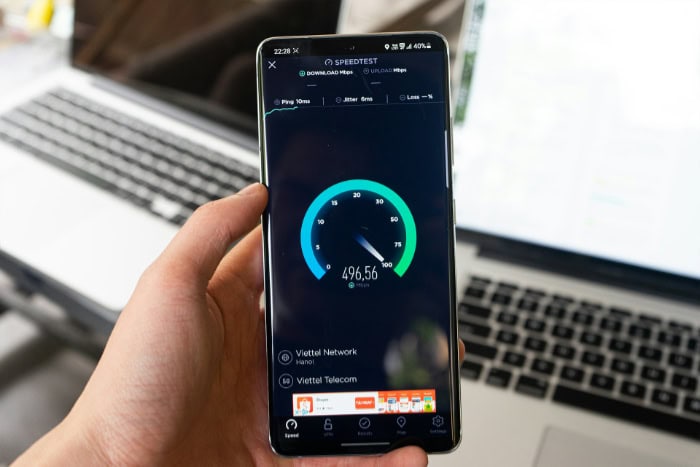 Hand holding smartphone displaying Speedtest app