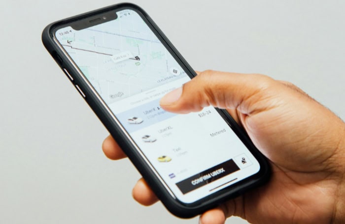 Hand holding smartphone displaying uber app interface