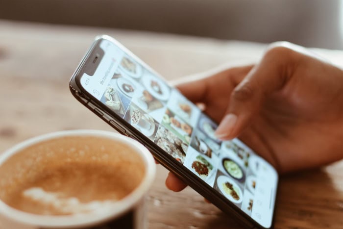 Hand scrolling through food photos on smartphone