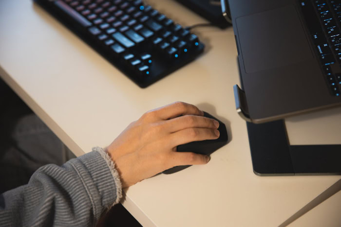 Hand using a computer mouse at a desk