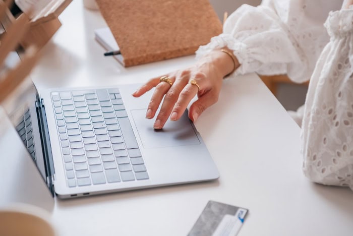 Hand using a laptop touchpad while shopping online