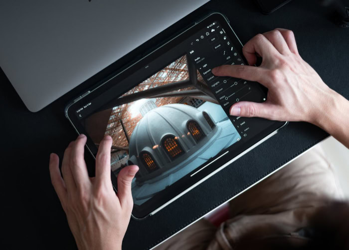 Hands editing photo on Adobe Lightroom tablet app