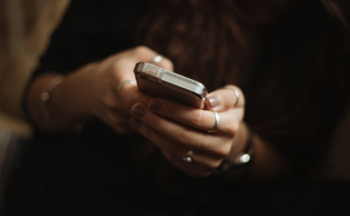 Hands holding iphone in dark setting