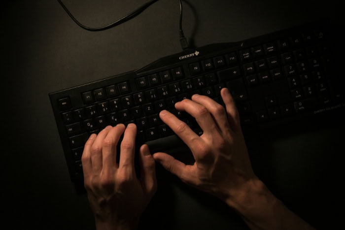 Hands typing on a black mechanical keyboard