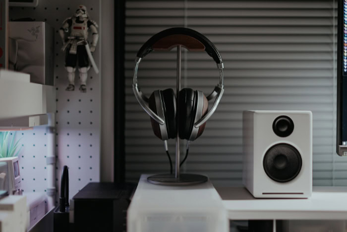 Headphones on a stand beside a speaker