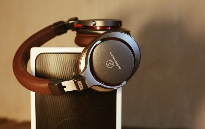 High end over ear headphones resting on portable speaker