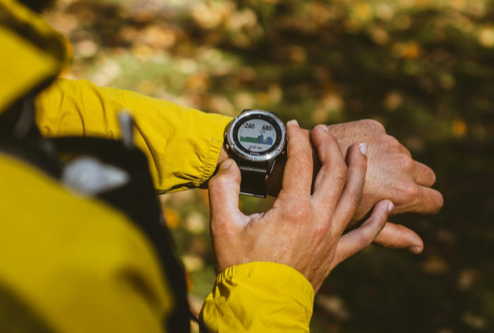 Hiker checking GPS sports watch in forest