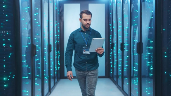 IT engineer in server room with tablet