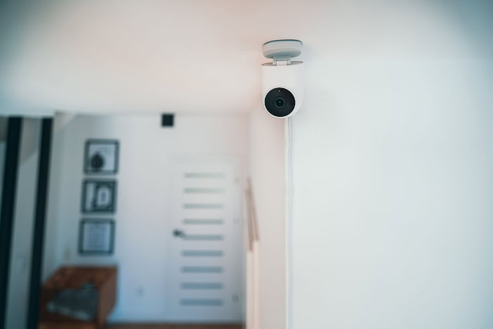 Indoor white security camera mounted on ceiling