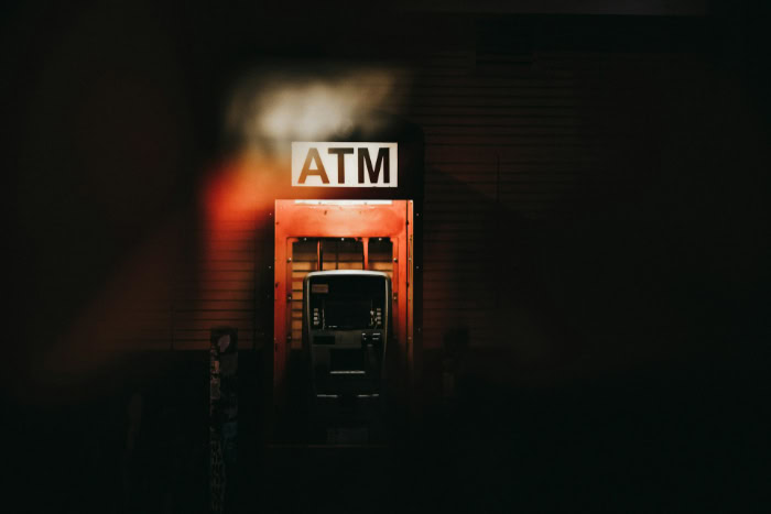 Isolated red ATM booth at night