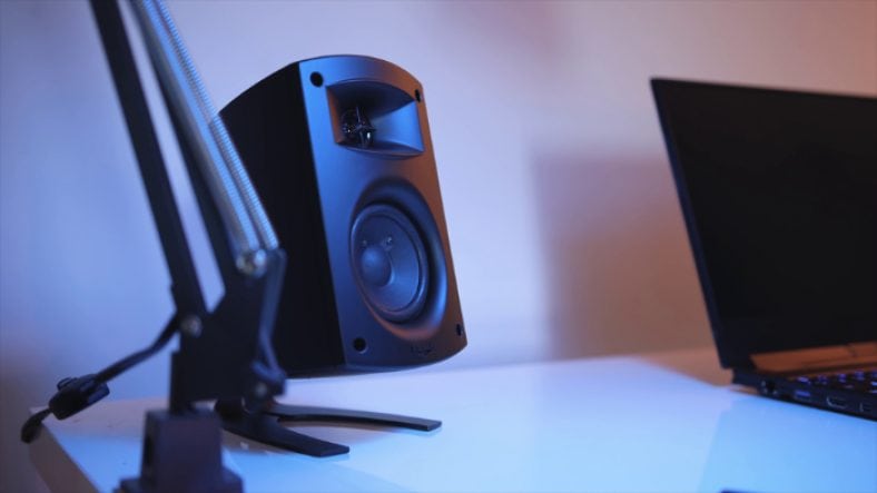 Black Klipsch ProMedia 2.1 near black laptop on white table