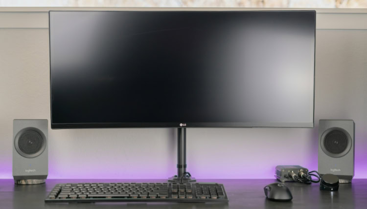 LG curved monitor on desk with Logitech speakers