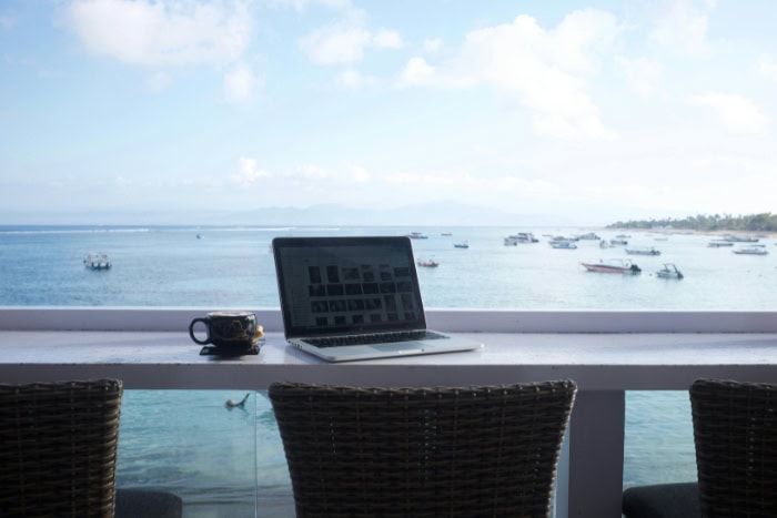 Laptop and coffee on balcony with ocean view