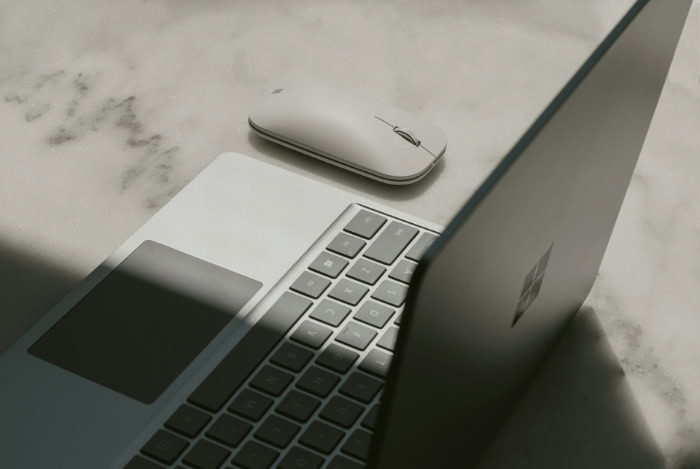 Laptop and wireless mouse on table