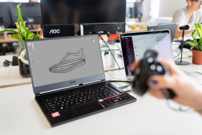 Laptop displaying 3D sneaker design with motion controller