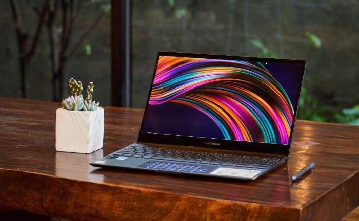 Laptop displaying colorful abstract design on wooden table