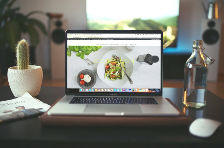 Laptop on a desk displaying a website