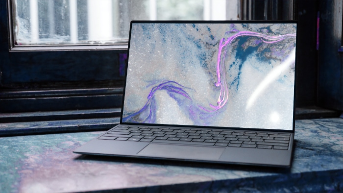 Laptop on a marble surface near a window