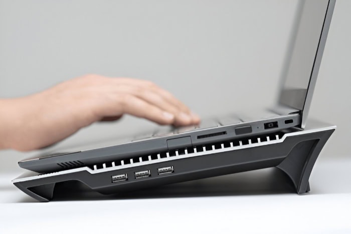 Laptop on ergonomic cooling pad with USB ports