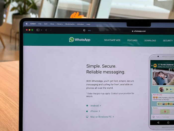Laptop screen showing WhatsApp official website and features