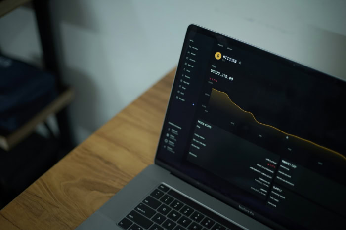 Laptop showing Bitcoin trading dashboard with price statistics