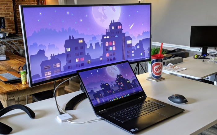 Laptop with a widescreen monitor showcasing matching cityscape wallpapers