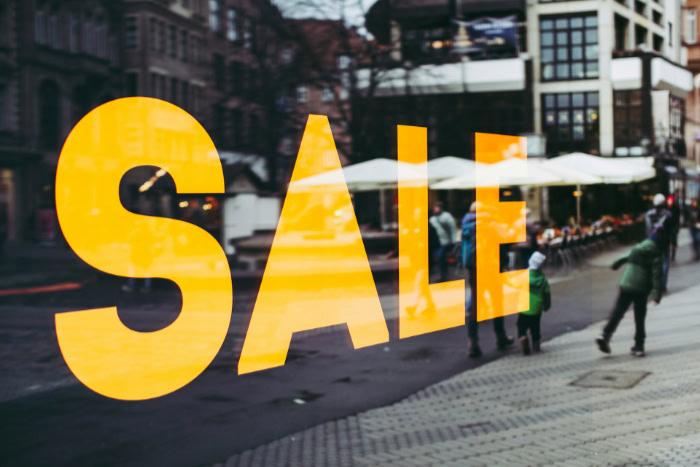 Large yellow sale sign on a storefront window