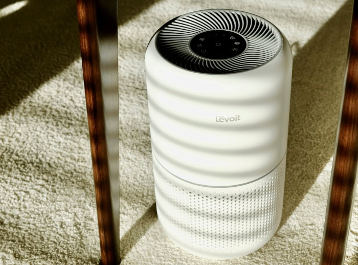 Levoit air purifier on a carpet under table