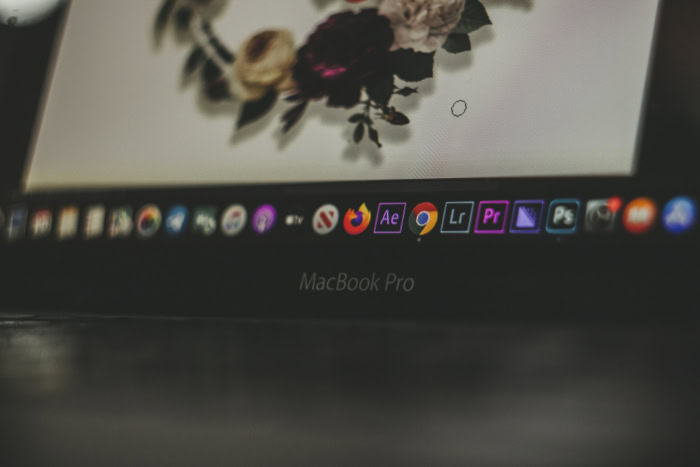 MacBook Pro screen with creative software icons visible