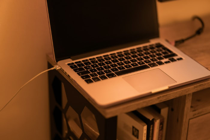 MacBook charging in warm ambient light