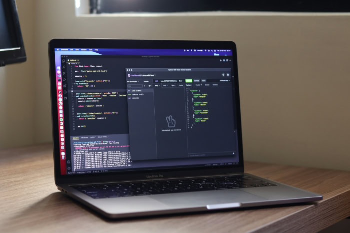 MacBook displaying Python Flask code and API client