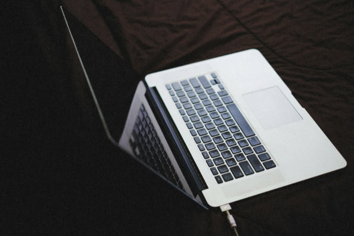 MacBook laptop open on dark fabric background