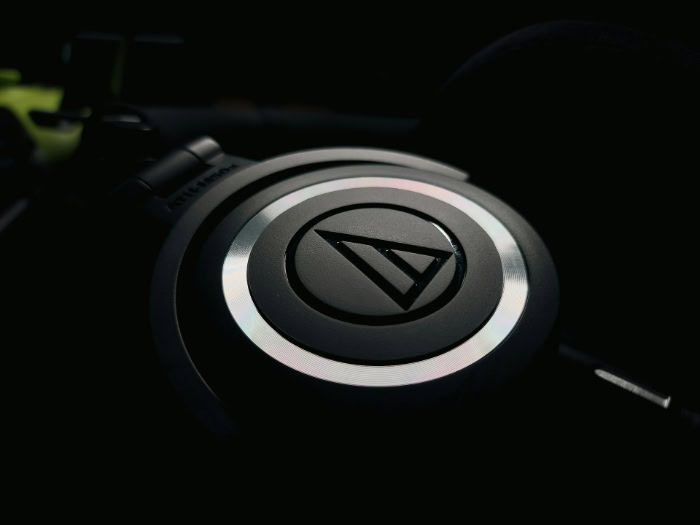 Macro shot of black Audio Technica headphone earcup logo