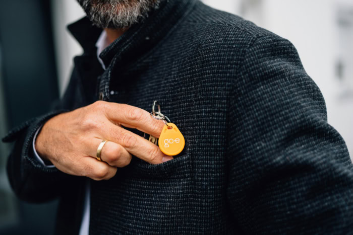 Man holding orange go e RFID key fob on keychain