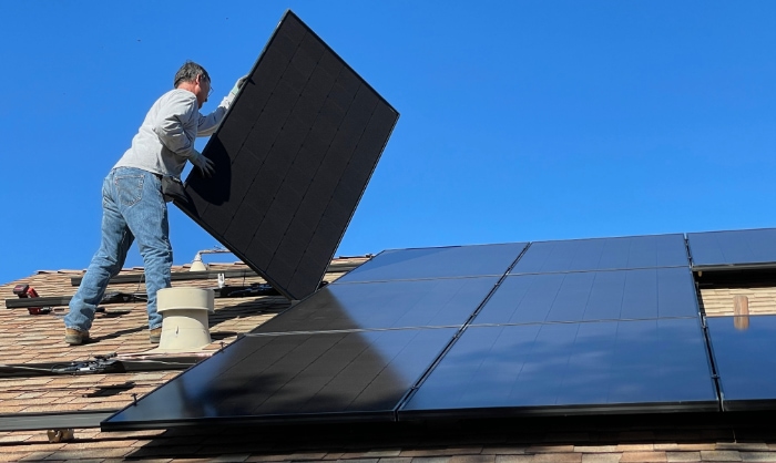 Man installing solar panel on the roof
