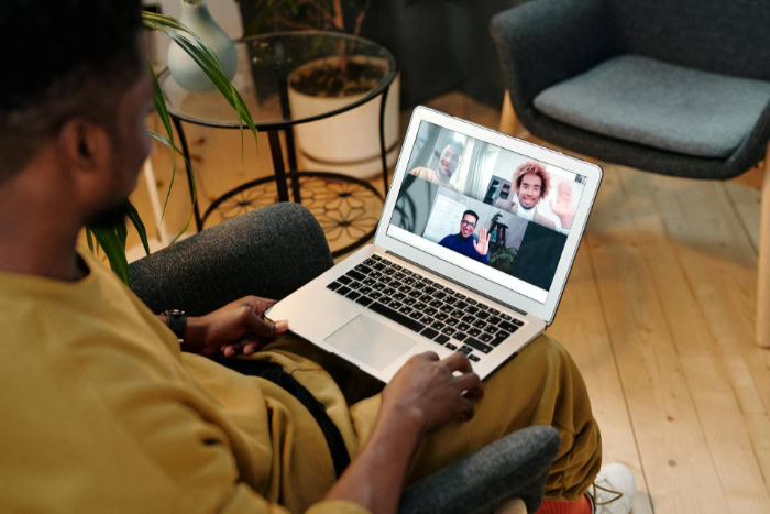 Man participating in a group video conference from a chair