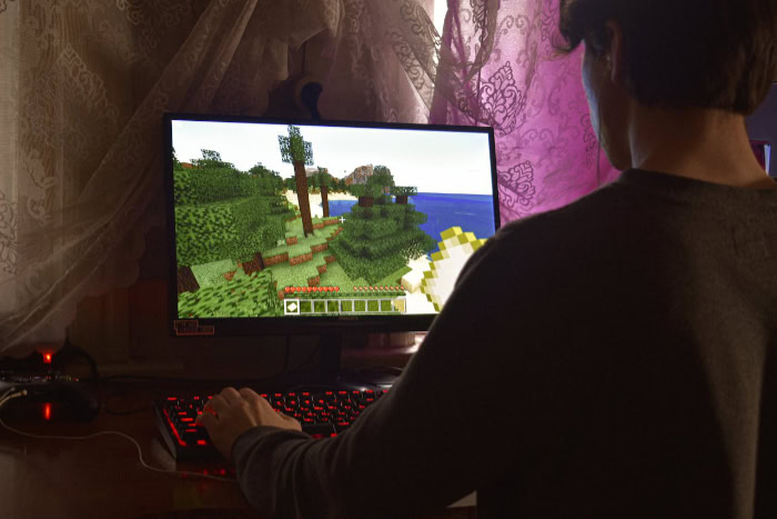 Man playing Minecraft video game on a computer