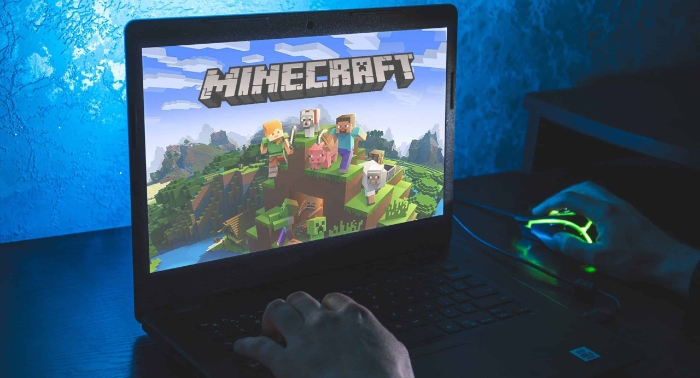 Man playing minecraft on laptop